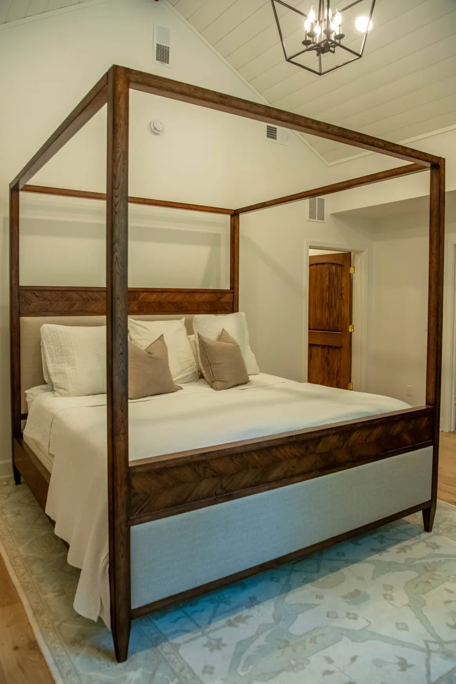 Primary bedroom with a four-poster bed under a vaulted shiplap ceiling