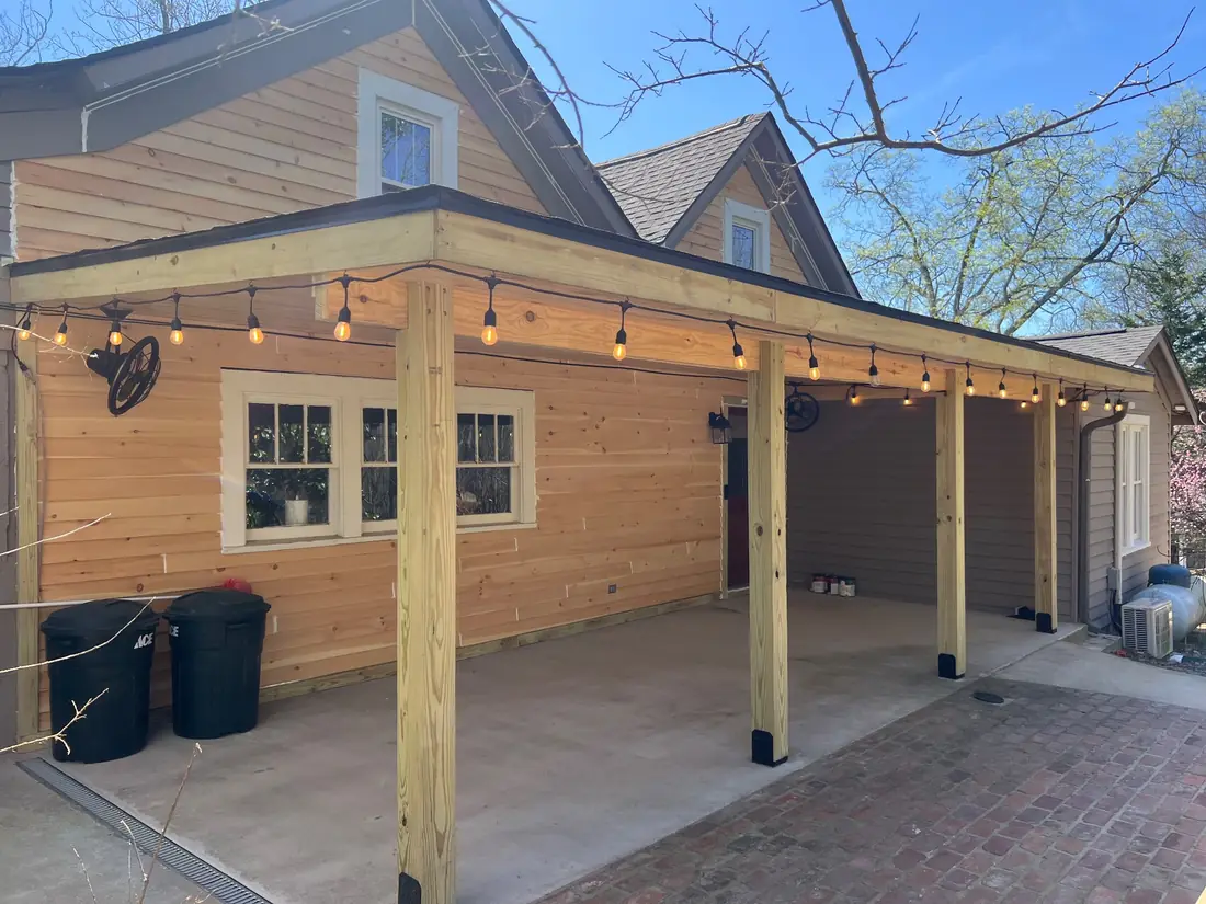 New siding and covered patio roof with string lighting