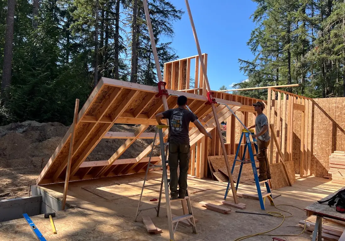 Wall framing being raised on the same home